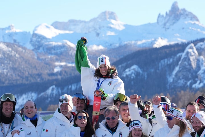 Italy's Federica Brignone (center) celebrates with the Italian athletes after winning the gold medal on Sunday.